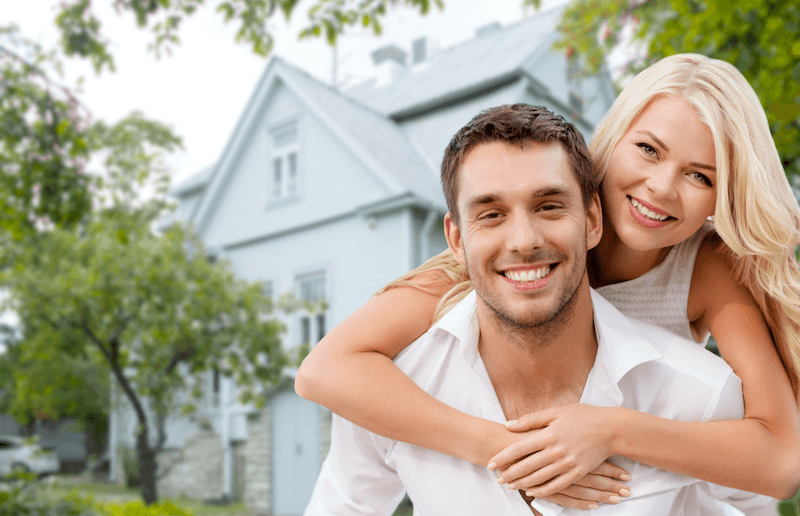 happy couple infront of insured home in Corpus Christi